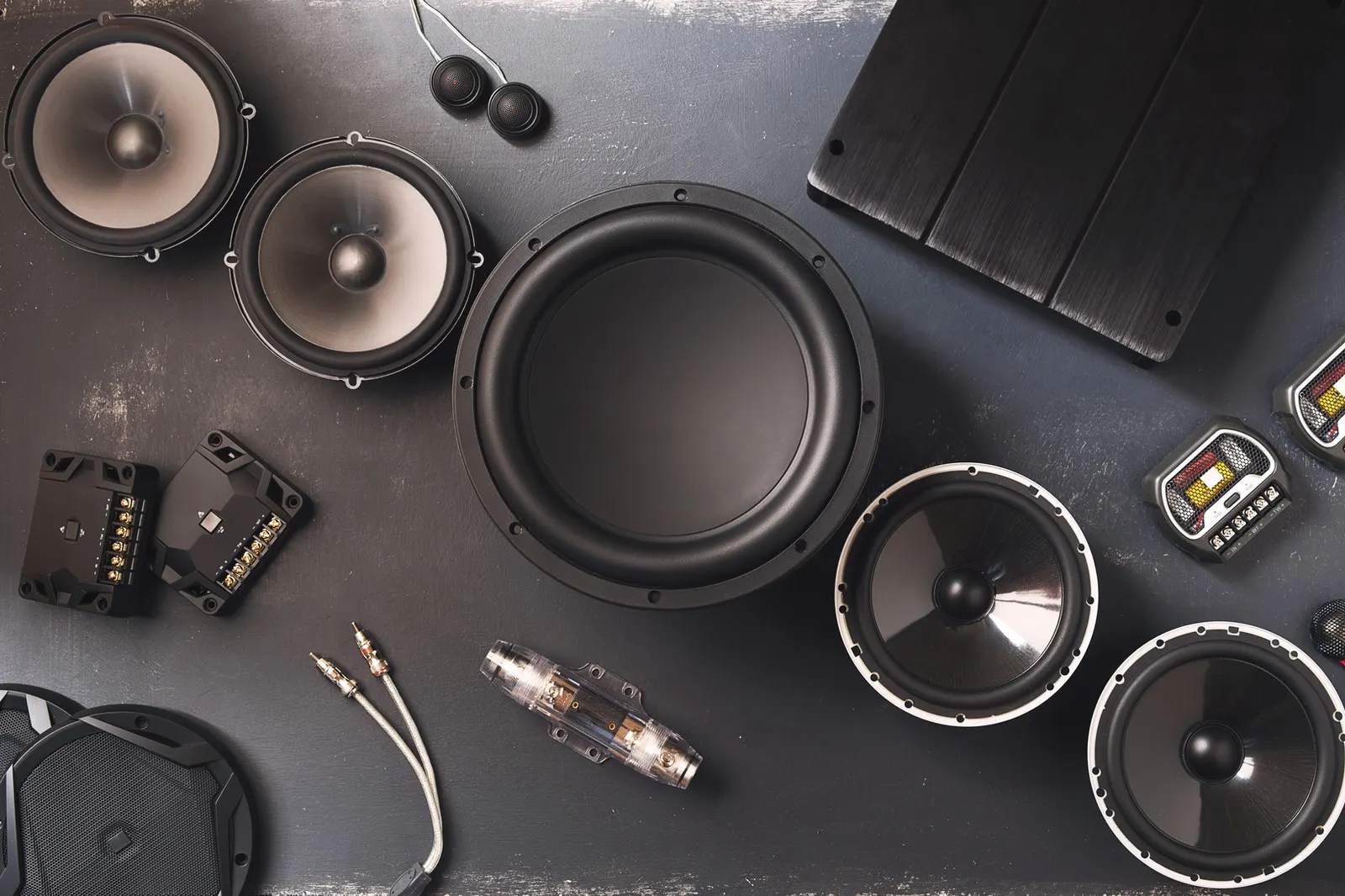 Car audio speakers, subwoofer and amplifier laid out for installation